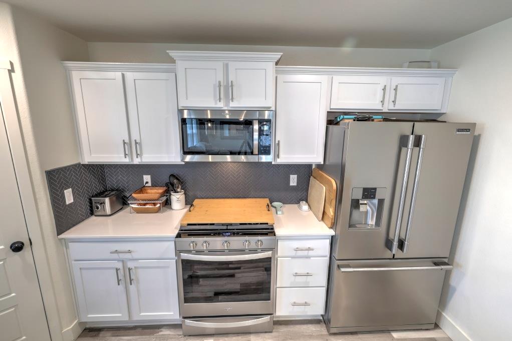 2129 Redding Way Atwater, CA 95301 - Photo 16 of 75 a kitchen with stainless steel appliances a refrigerator stove and microwave