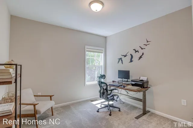 a view of a workspace with furniture and a window