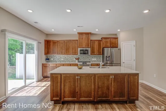 a large kitchen with kitchen island granite countertop a stove a sink and a granite counter top