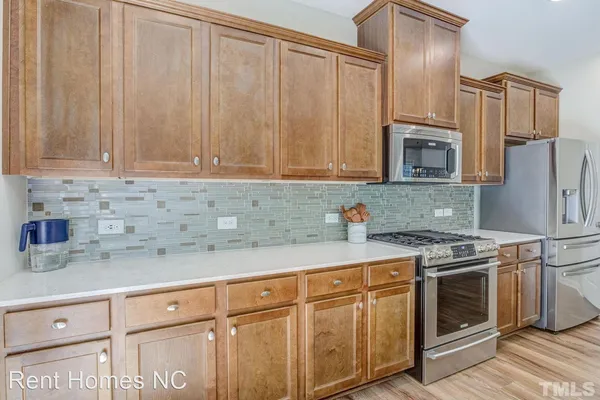 a kitchen with stainless steel appliances granite countertop white cabinets a stove a sink and dishwasher