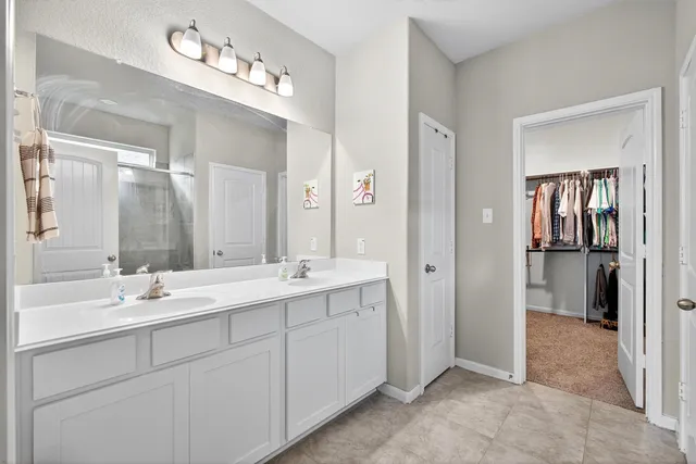 a spacious bathroom with a double vanity sink mirror and shower