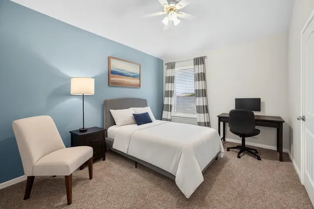 a bedroom with a bed a desk and chair