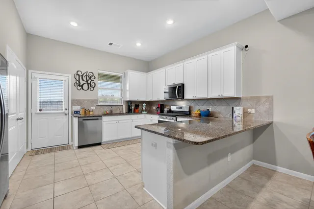 a kitchen with stainless steel appliances granite countertop a sink and cabinets