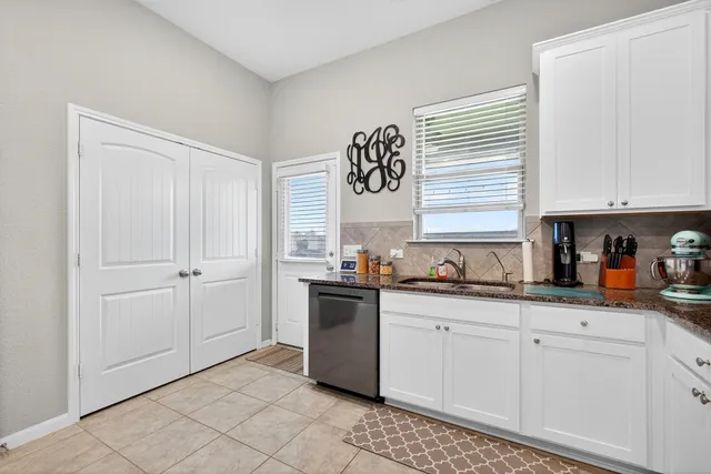 a kitchen with granite countertop white cabinets and white appliances
