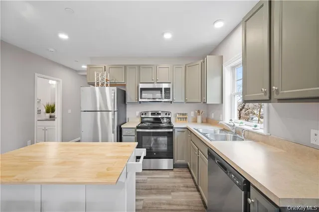 a kitchen with kitchen island a sink stove and refrigerator