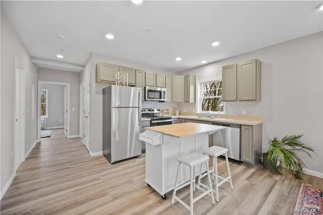 a kitchen with granite countertop white cabinets and stainless steel appliances
