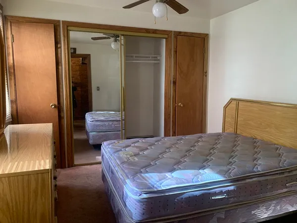 a bedroom with a bed and cabinet