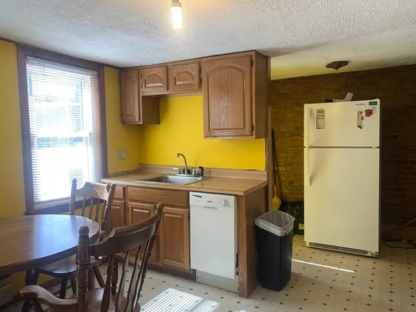 a kitchen with a refrigerator a stove a sink and a dining table