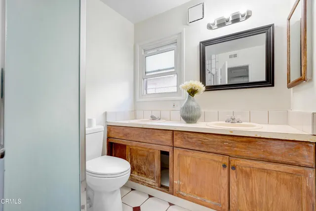 a bathroom with a toilet a sink and mirror