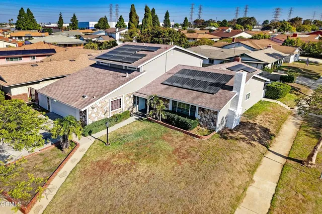 an aerial view of multiple houses with a yard