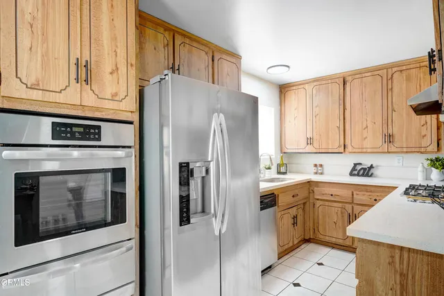 a kitchen with stainless steel appliances a refrigerator sink and cabinets