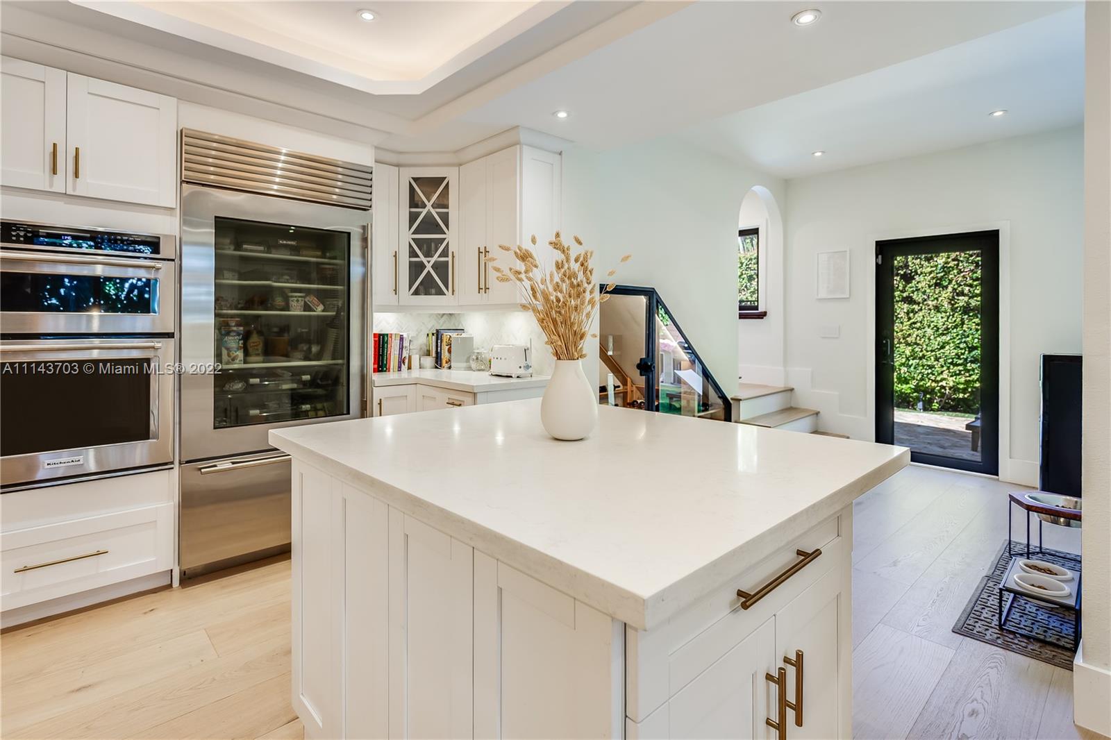 4422 Alton Road Miami Beach, FL 33140 - Photo 13 of 37 a kitchen with kitchen island a stove a sink and a refrigerator