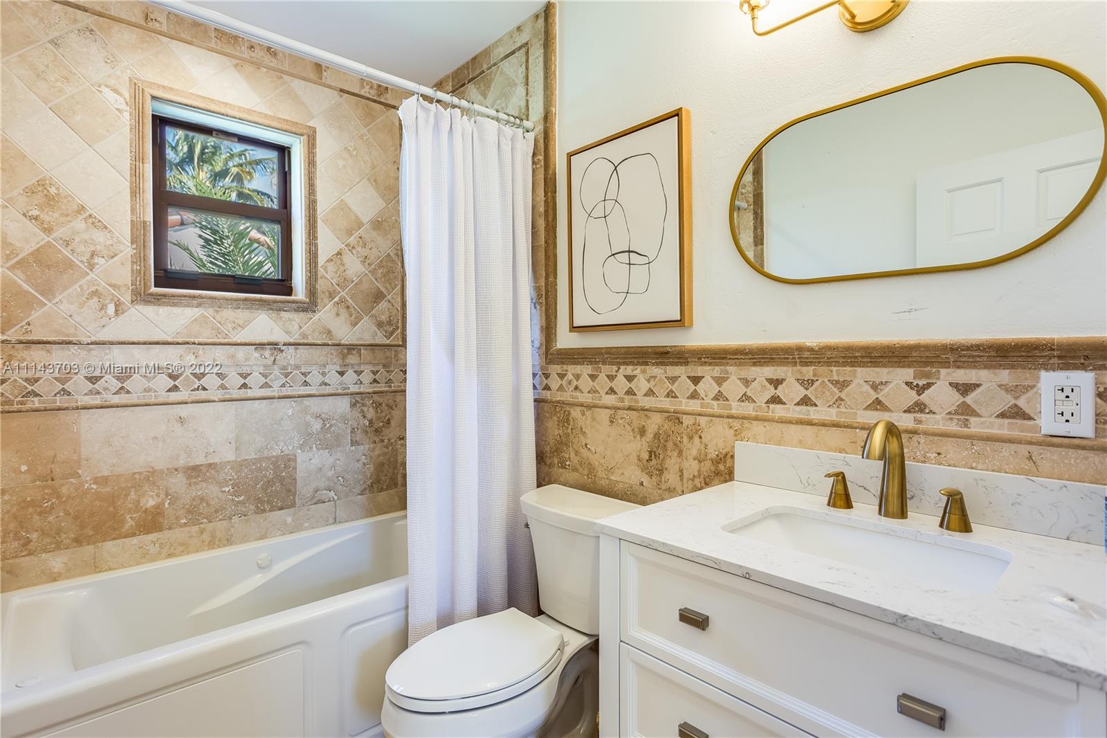 4422 Alton Road Miami Beach, FL 33140 - Photo 21 of 37 a bathroom with a toilet a sink and a mirror