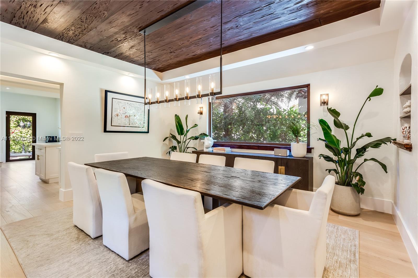 4422 Alton Road Miami Beach, FL 33140 - Photo 7 of 37 a kitchen with stainless steel appliances a table a potted plant on the granite counter tops and a window