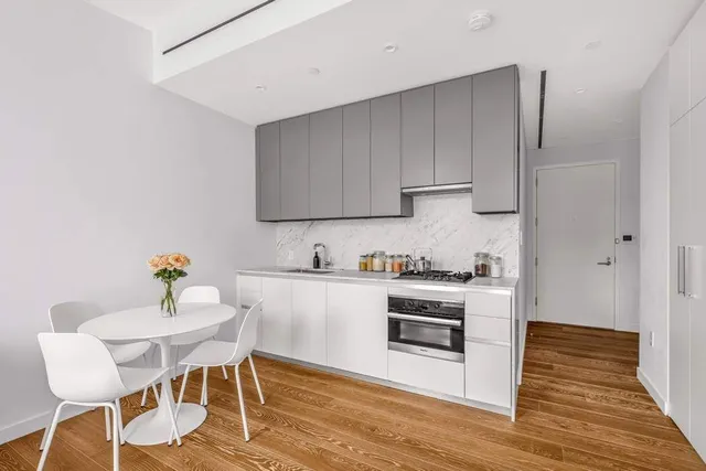 a kitchen with stainless steel appliances a stove a sink cabinets and wooden floor