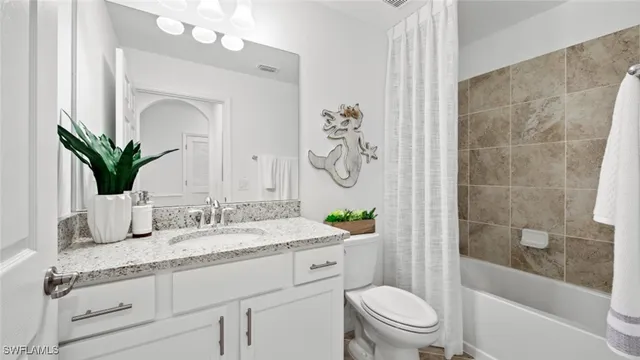 a bathroom with a granite countertop sink mirror toilet and a bathtub