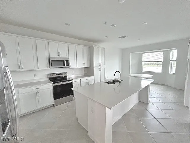 a kitchen with stainless steel appliances a sink stove and cabinets