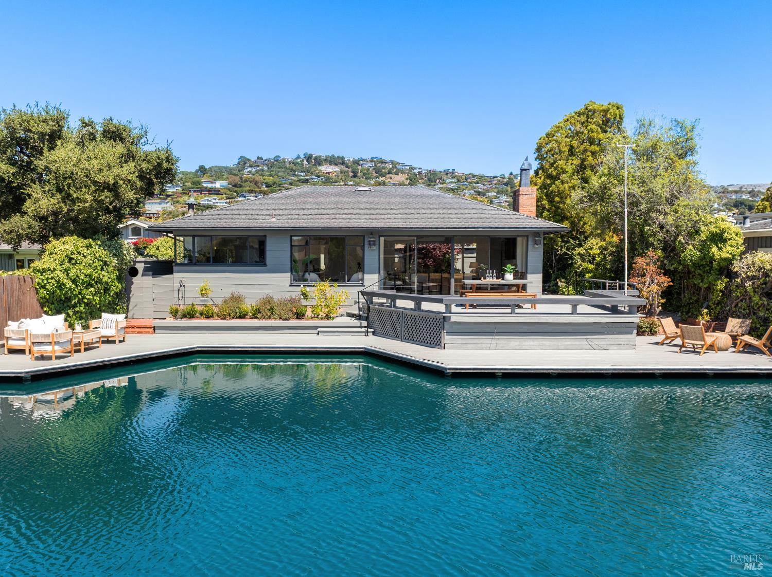 a view of a swimming pool with outdoor seating and a garden