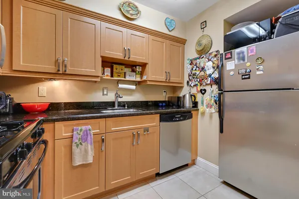 a kitchen with stainless steel appliances granite countertop a refrigerator and a stove