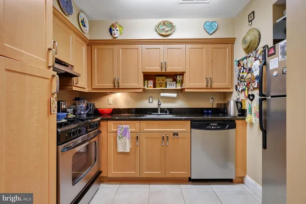 a kitchen with stainless steel appliances granite countertop a refrigerator and a stove