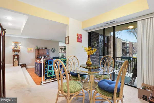 a dining room with furniture a rug and white walls