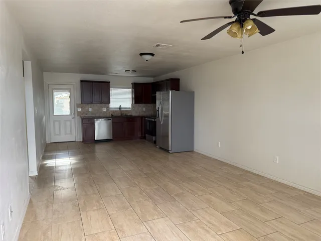 a view of kitchen with refrigerator cabinets and furniture