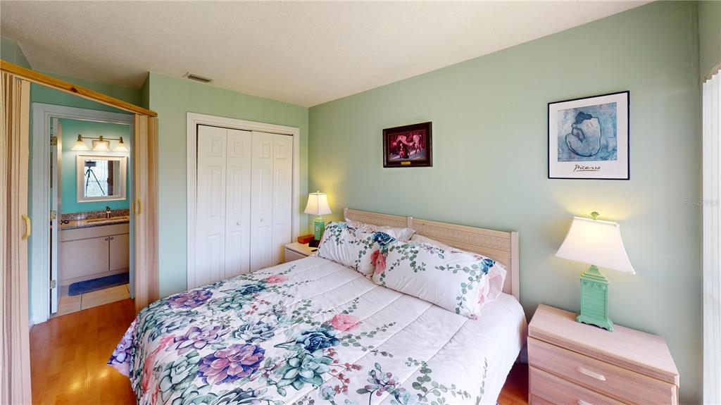 3415 Clark Road, Unit 215 Sarasota, FL 34231 - Photo 12 of 18 a bedroom with a bed and a painting on the wall