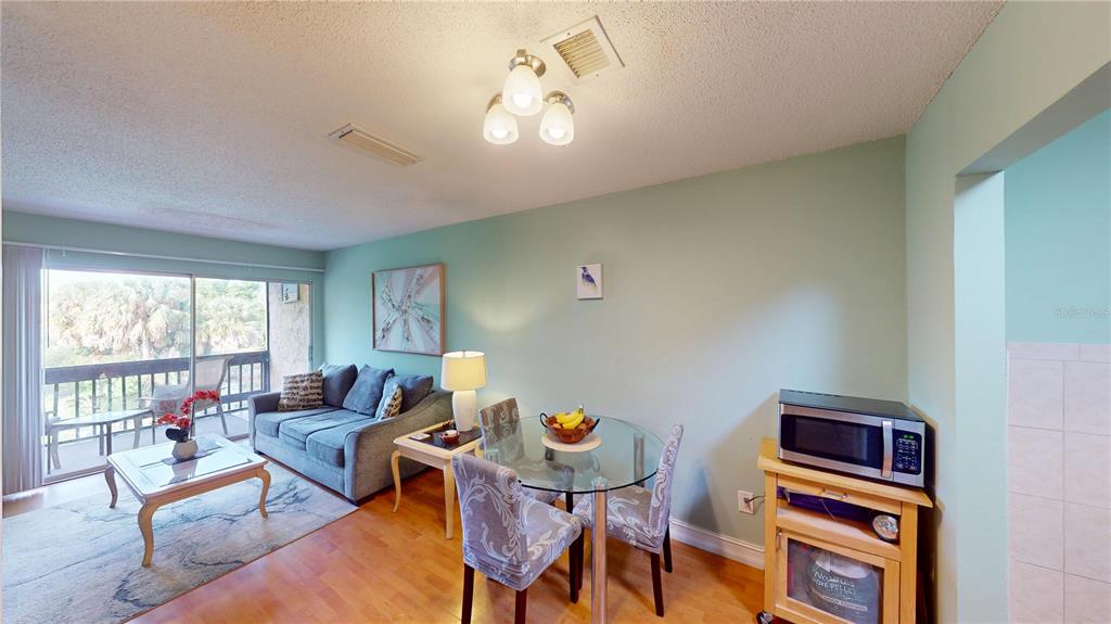 3415 Clark Road, Unit 215 Sarasota, FL 34231 - Photo 7 of 18 a living room with furniture a window and a flat screen tv