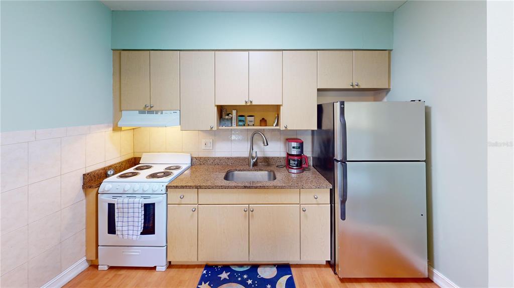 3415 Clark Road, Unit 215 Sarasota, FL 34231 - Photo 8 of 18 a kitchen with a refrigerator sink stove and cabinets