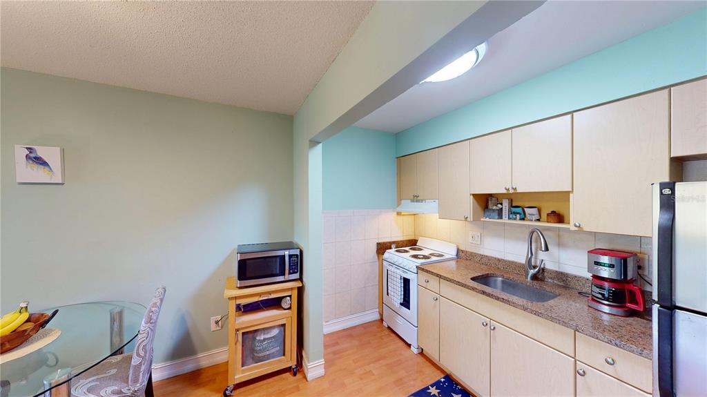 3415 Clark Road, Unit 215 Sarasota, FL 34231 - Photo 8 of 18 a kitchen with stainless steel appliances granite countertop a sink stove and cabinets