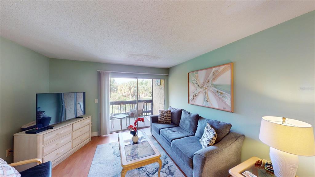 3415 Clark Road, Unit 215 Sarasota, FL 34231 - Photo 10 of 18 a living room with furniture and a flat screen tv
