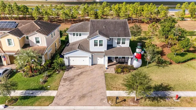 an aerial view of a house with a yard and large tree