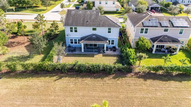 an aerial view of a house with swimming pool and a yard