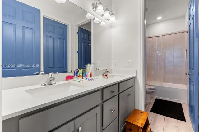 a bathroom with a double vanity sink a toilet and a large mirror