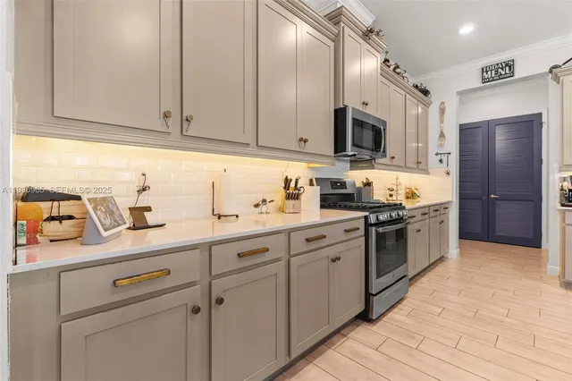 a kitchen with stainless steel appliances granite countertop a sink and a stove
