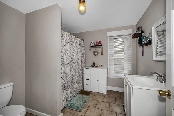 a bathroom with a granite countertop toilet and a sink