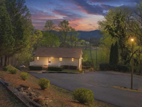 a front view of a house with a yard and mountain view
