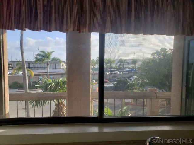 a view of an empty room with a sliding door and windows