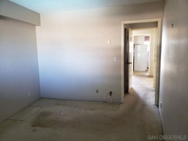 a view of a hallway to a room with windows