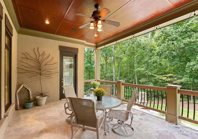 a roof deck with table and chairs and potted plants