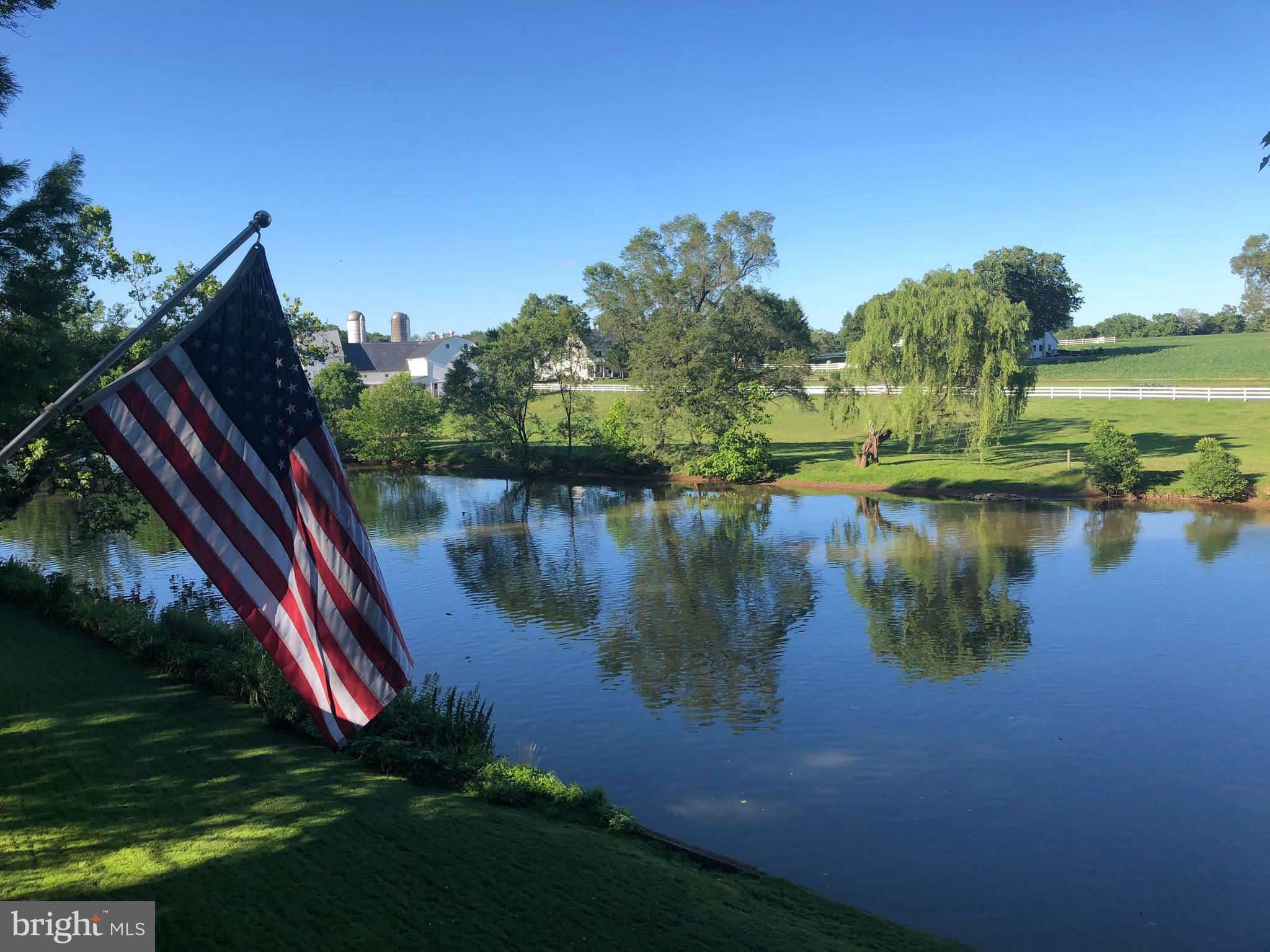 291 Bushong Road Leola, PA 17540 - Photo 2 of 81 a view of a lake with a yard and large trees