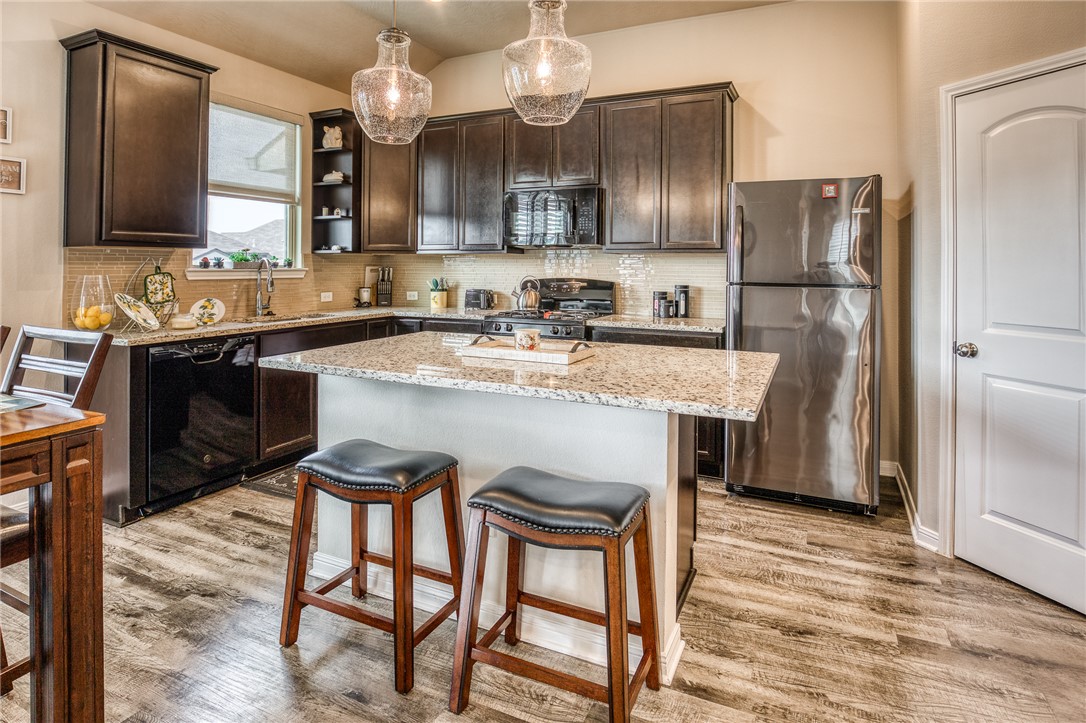 1004 Rootstock Rd. Brenham, TX 77833 - Photo 1 of 1 Kitchen with dark brown cabinetry, hanging light f