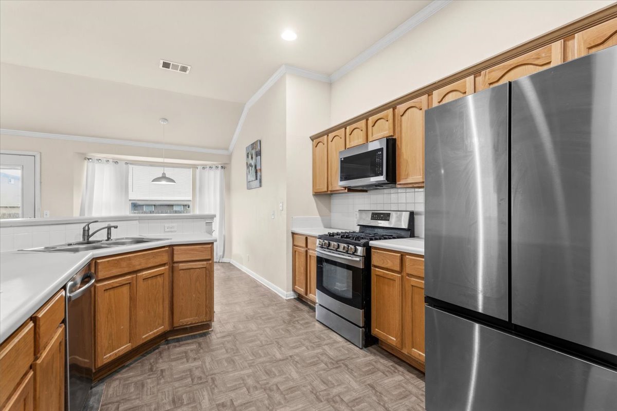 281 Leonardo Kyle, TX 78640 - Photo 9 of 38 a kitchen with stainless steel appliances granite countertop a refrigerator stove and sink
