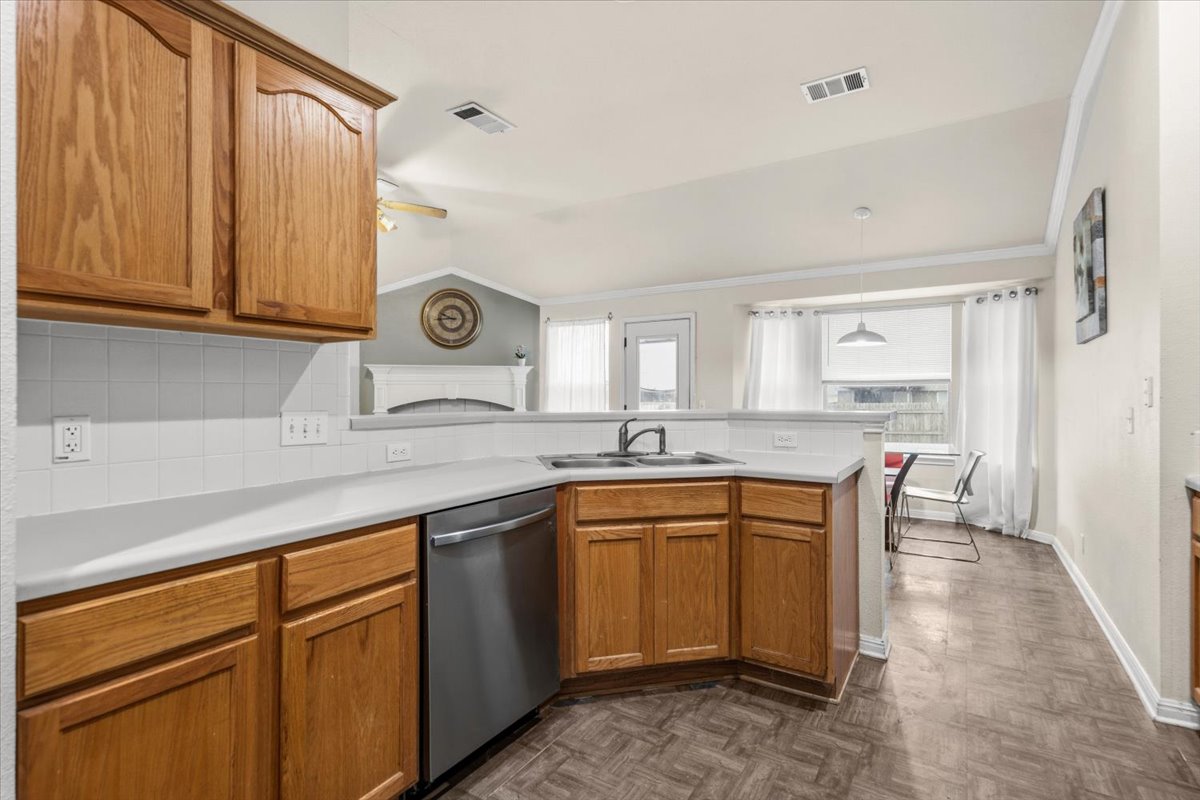 281 Leonardo Kyle, TX 78640 - Photo 10 of 38 a kitchen with stainless steel appliances granite countertop a sink and cabinets with wooden floor