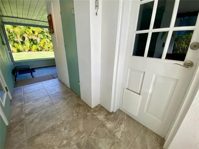 a view of a house with a yard potted plants and a table