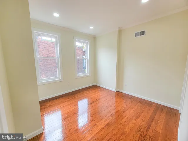 a view of empty room with wooden floor
