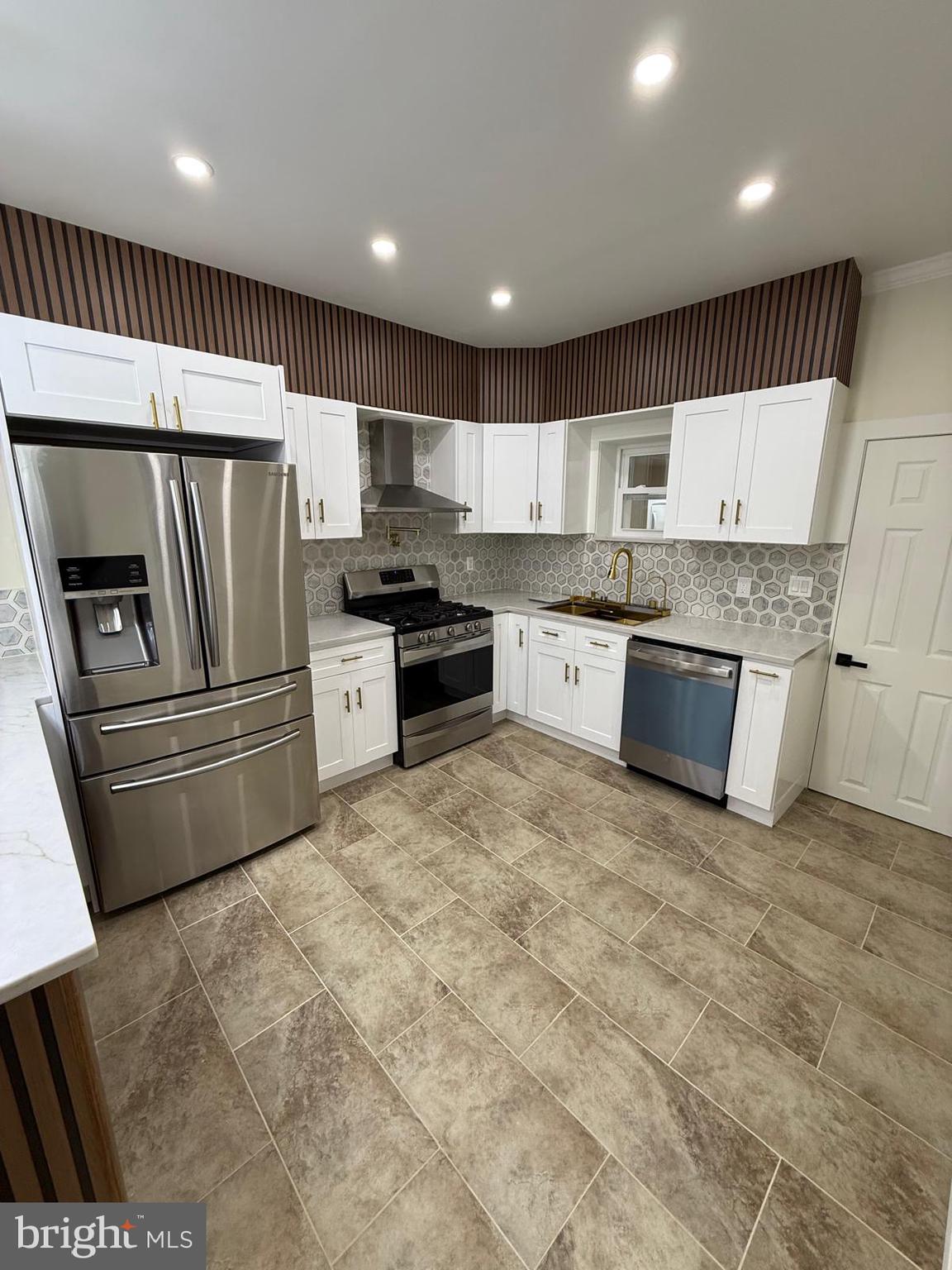 5502 Master Street Philadelphia, PA 19131 - Photo 32 of 63 a kitchen with stainless steel appliances granite countertop a stove a sink and a refrigerator
