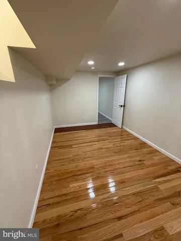 a view of a hallway with wooden floor and a window