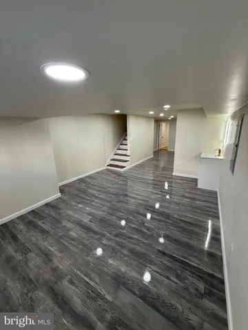 a view of empty room with window and wooden floor