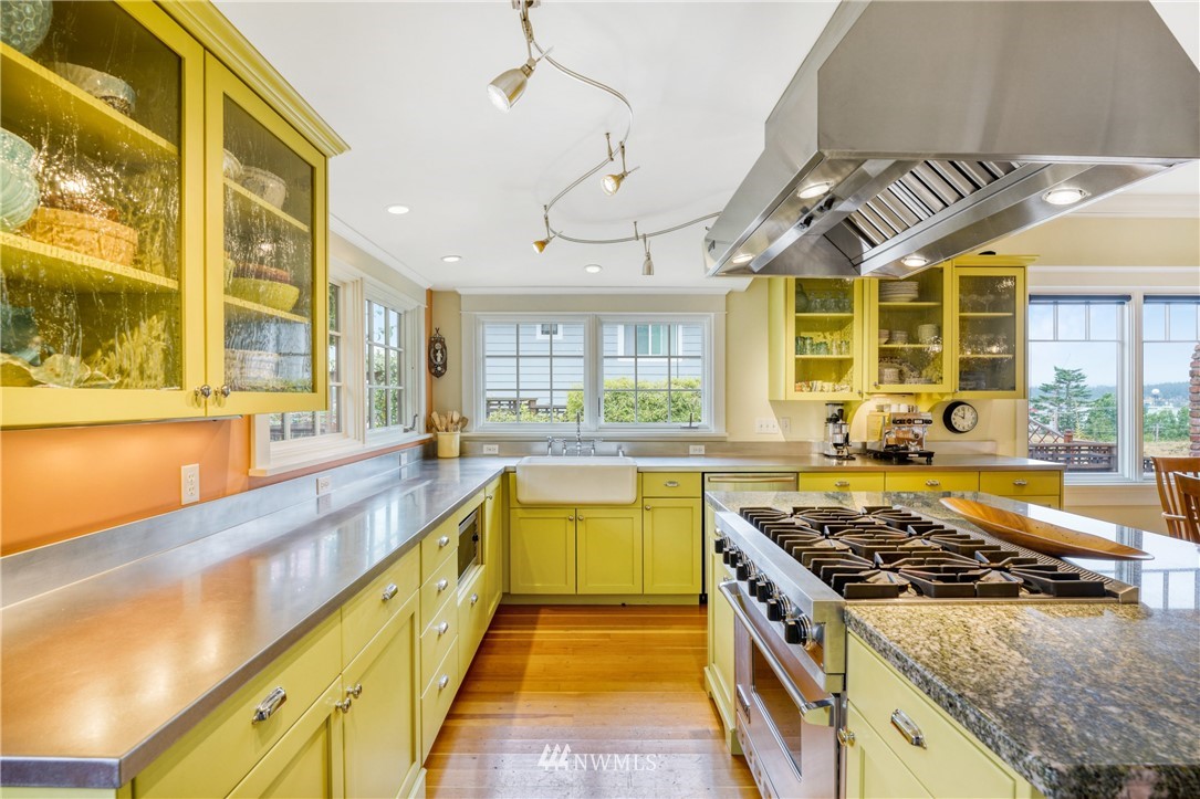 415 5th Street Anacortes, WA 98221 - Photo 12 of 38 a large kitchen with stainless steel appliances granite countertop a stove and a large window